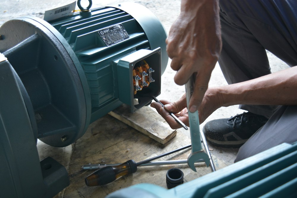 Técnico reparando un motor eléctrico con llave